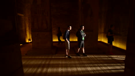 Escena-Sombría-De-Turistas-Caminando-Dentro-Del-Templo-De-Abu-Simbel-En-Egipto