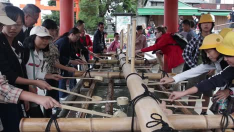 Tourists-washing-their-hand-at-the-temple-in-Kyoto-to-become-clean-before-prayer