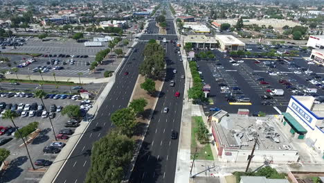 Aerial-drone-flying-North-over-Hawthorne-Blvd-traffic,-homes-and-businesses