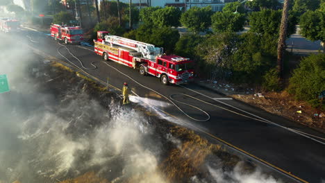 Aerial-view-of-a-LAFD-firefighter-extinguishing-a-park-fire,-in-Los-Angeles,-USA