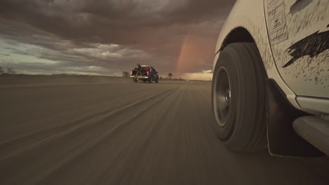 Camión-Montando-Un-Camino-De-Arena-Hacia-El-Desierto-Relámpago-Tormenta-Al-Anochecer-En-Namibia---Pov-Nivel-Del-Suelo-Plano-Amplio