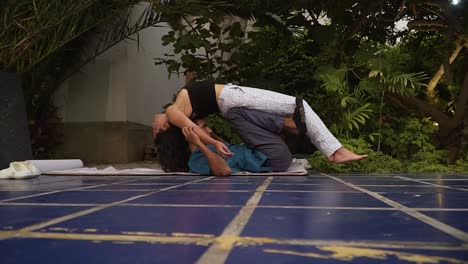 Young-Man-And-Woman-Posing-Together-On-Ground-In-Yoga-Session,-Lima,-Peru