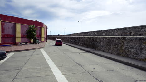 Autos,-Die-An-Den-Mauern-Von-Cartagena-Vorbeifahren,-Verbinden-Die-Alte-Kolonialarchitektur-Mit-Der-Moderne