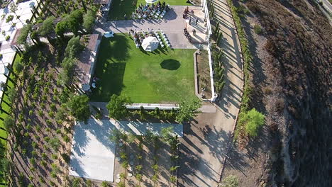 Aerial-drone-slowly-rising-over-winery-during-wedding