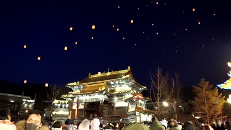 Gubei-Water-Town-New-Chinese-Year-Celebration-2020,-people-looking-up-the-sky-as-artificial-traditional-lanterns-are-lifted-by-drones