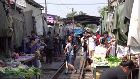 Menschen-Und-Geschäfte-Unter-Zelten-Auf-Dem-Maeklong-Eisenbahnmarkt,-Thailand