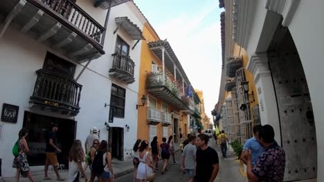 A-group-of-tourists-is-walking-down-the-street-of-the-old-town-of-Cartagena-de-Indias,-Colombia