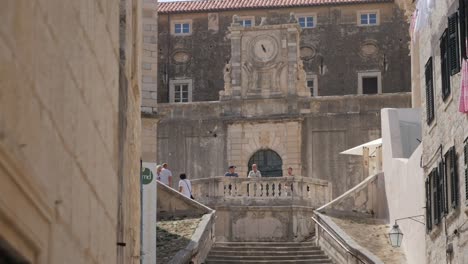 Historical-stairs-of-Jesuit-and-buildings-with-many-people-and-bird-flying,-camera-motion-view