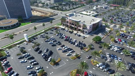 Aerial-Drone-flying-North-West-across-Del-Amo-Fashion-Center-parking-lot-and-shops-with-main-street-and-construction-in-background