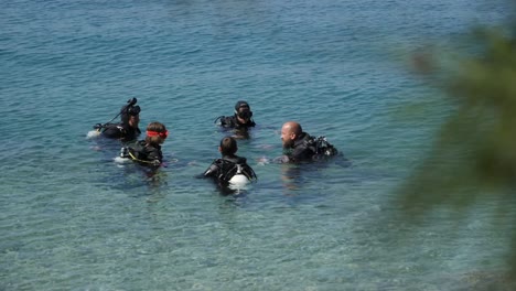 Group-of-people-listening-scuba-diving-instructor-near-coastline-of-Croatia