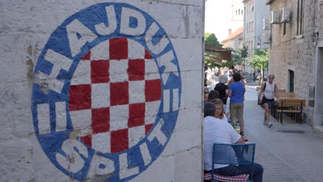 Split-Hajduk-Logo-Graffiti-Und-Gasse-Mit-Menschen