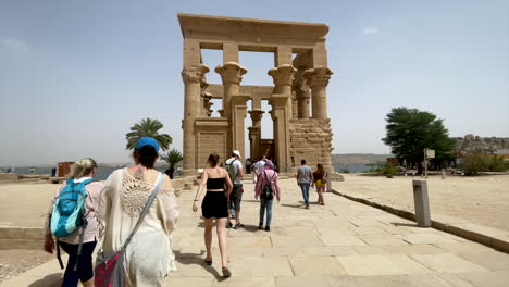 Group-of-tourists-walking-outside-egyptian-temple-of-Isis-at-Philae,-Egypt