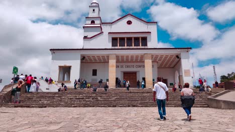 Tourists-and-local-people-walking-towards-a-white-church-on-top-of-the-Monserrate-cable-car-in-Bogotá,-Colombia