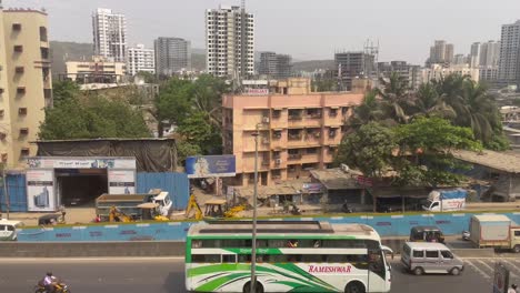 Traveling-Bus-And-Motorcycles-On-The-Busy-Freeway-Of-Mumbai-Metro,-Overlooking-The-Modern-Structures-Of-India