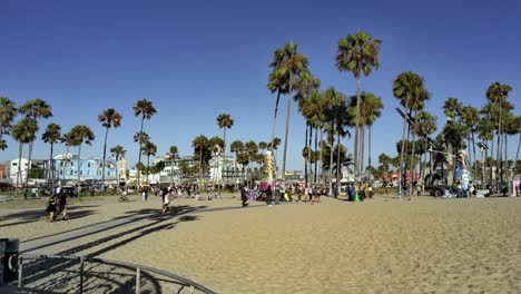 Menschen,-Die-Während-Der-Golden-Hour-In-Los-Angeles,-Kalifornien,-USA,-Auf-Dem-Sand-An-Der-Strandpromenade-Von-Venice-Spazieren-–-Handaufnahme