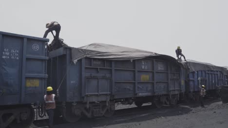 Trabajadores-Industriales-Que-Cubren-Carbón-Cargado-En-Vagones-De-Carga-Para-Transporte