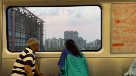 Un-Hombre-Y-Una-Mujer-Mayores-Conversando-Mientras-Están-Sentados-Dentro-Del-Tren-Y-Mirando-Fuera-De-La-Vista-Del-Metro-De-Mumbai