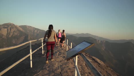 Cinematic-gimbal-shot-of-tourists-enjoying-the-view-from-the-peak-of-Moro-Rock-in-California's-Sequoia-National-Forest