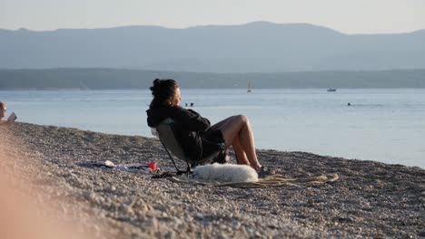 Woman-with-white-dog-sunbathing-on-beach