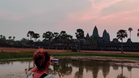 Panning-of-Angkor-Wat-Temple-where-a-person-is-seen-taking-a-picture-of-the-sunrise