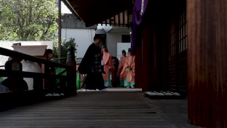 Japanische-Mönche-Sitzen-Vor-Dem-Haus-Und-Warten-Darauf,-Dass-Der-Priester-Herauskommt