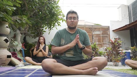 Tiro-De-Retroceso-Hacia-Una-Entrenadora-De-Yoga-Meditando-En-La-Naturaleza-Con-Sus-Alumnos,-Lima,-Perú.