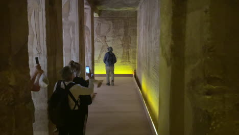 Un-Turista-Mayor-Toma-Una-Fotografía-Dentro-De-Un-Templo-Egipcio-En-Abu-Simble,-Egipto