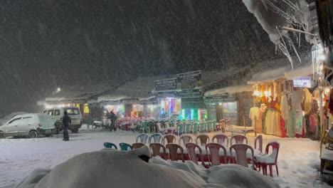 Snow-Falling-On-A-Winter-Night-At-The-Gulmarg-Market-In-Kashmir,-India