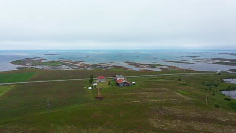 Aerial-view-around-a-farm-on-the-coast-of-Andoya,-dark,-overcast-day,-in-Norway---Circling,-drone-shot