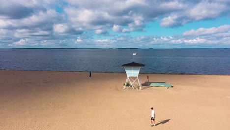 Aerial-view-of-the-lifeguard-house,-at-Nallikari-beach,-in-Oulu,-Finland---tracking,-drone-shot