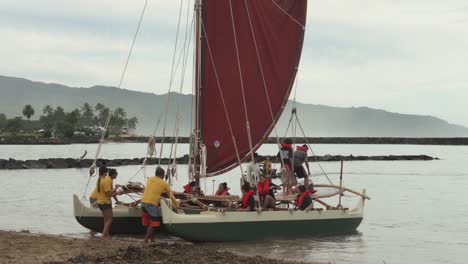 Escuela-De-Vela-Preparándose-Para-Lanzar-Al-Mar-Una-Canoa-Polinesia-De-Recreo-De-Doble-Casco
