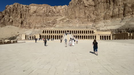 Travel-girl-walks-towards-Queen-Hatshepsut-Temple-at-The-Valley-of-the-Kings,-Egypt