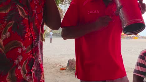 Man-dances-to-Vallenato-and-local-songs-as-he-plays-the-Guacharaca-on-a-beach-in-Cartagena-de-Indias,-Colombia