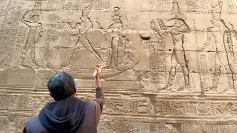 TOURIST-GUIDE-pointing-at-Egyptian-hieroglyphs