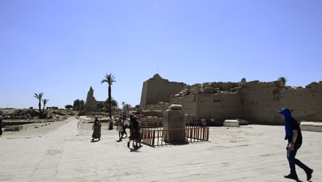 Touristen-Führen-Ritual-Des-Spaziergangs-Um-Die-Steinstatue-Eines-Frosches-Als-Glücksbringer-Durch,-Karnak-Tempel,-Ägypten