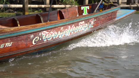 Zeitlupe-Eines-Lokalen-Thailändischen-Bootes,-Das-Auf-Dem-Weg-Zum-Schwimmenden-Markt-Im-Fluss-Segelt,-Filmisch,-Nahaufnahme