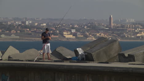 Pescador-Preparando-Cebo-Para-Pescar,-Ciudad-De-Argel,-Argelia