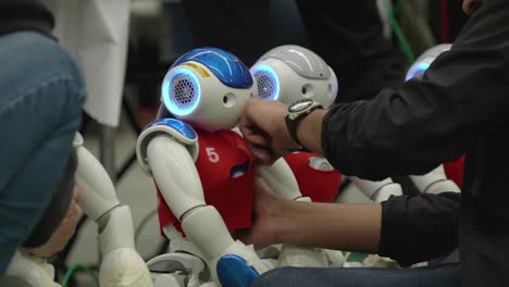 Engineer-Putting-On-Red-Bib-On-Nao-Robot-at-Football-Tournament-In-Montreal