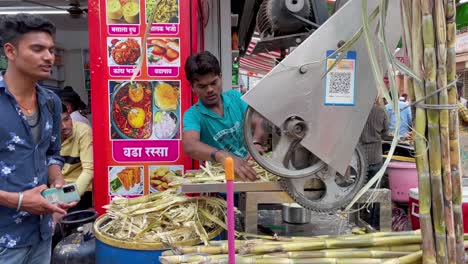 Indischer-Verkäufer,-Der-Süßen-Saft-Aus-Zuckerrohr-Auf-Einer-Maschine-In-Trimbakeshwar,-Indien,-Extrahiert