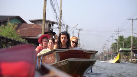 Filmische-Zeitlupenansicht-Von-Touristen-Auf-Einem-Boot,-Das-Auf-Einer-Schwimmenden-Markttour-In-Thailand-Segelt