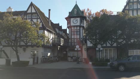 Looking-at-traditional-danish-architecture-and-cars,-in-Solvang-town,-California,-USA,-sunny-day---Pan-view