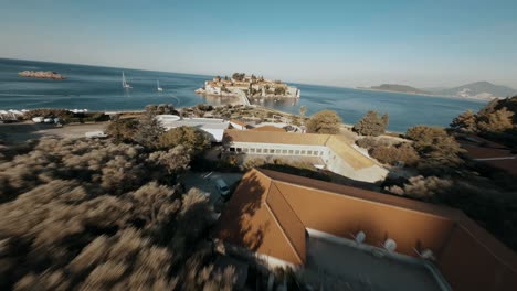 Fliegende-FPV-Drohne-In-Montenegro-Hinunter-Zur-Insel-Sveti-Stefan-über-Dem-Meer-In-Der-Nähe-Des-Strandes