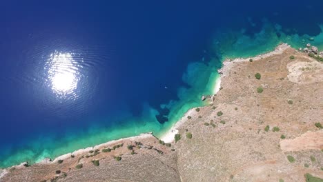 Panning-and-tilting-drone-shot-revealing-the-mountains-and-coastline-of-Agriosiko,-a-secret-beach-located-in-Kefalonia,-Greece