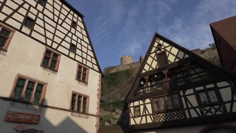 Scenic-medieval-town-with-half-timbered-architectural-buildings-and-castle-on-top-of-the-hill-on-a-clear-day