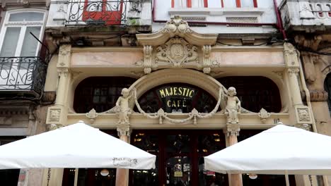 Handheld-tilt-down-of-famous-Cafe-Majestic-facade,-Porto,-Portugal