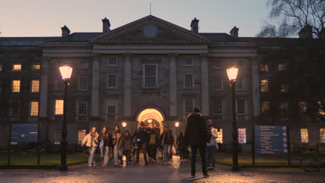 Students-walking-in-the-late-afternoon-at-the-entrance-to-Trinity-College-in-Dublin,-Ireland