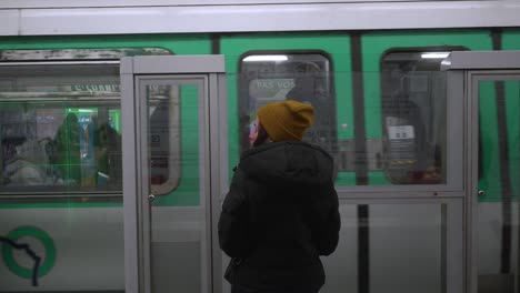 Eine-Passagierin-Wartet-Auf-Die-U-Bahn,-Während-Die-Andere-Bahn,-Die-Grüne-U-Bahn,-Den-Bahnsteig-Verlässt