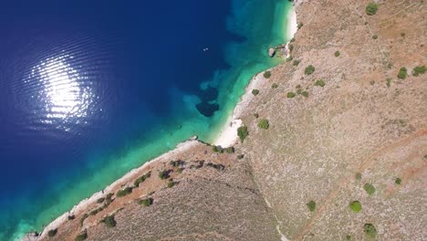 Orbiting-overhead-drone-shot-of-a-secluded-beach-located-in-Kefalonia-that-belongs-to-the-Ionian-Islands-in-Greece