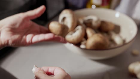 Woman's-Hand-Removing-Stem-Of-Mushroom-Then-Placed-In-The-Bowl