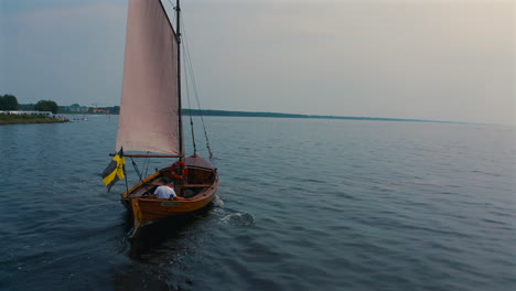 Drone-follows-wooden-pomeranian-boat-sailing-on-the-sea-in-Jastarnia,-Poland